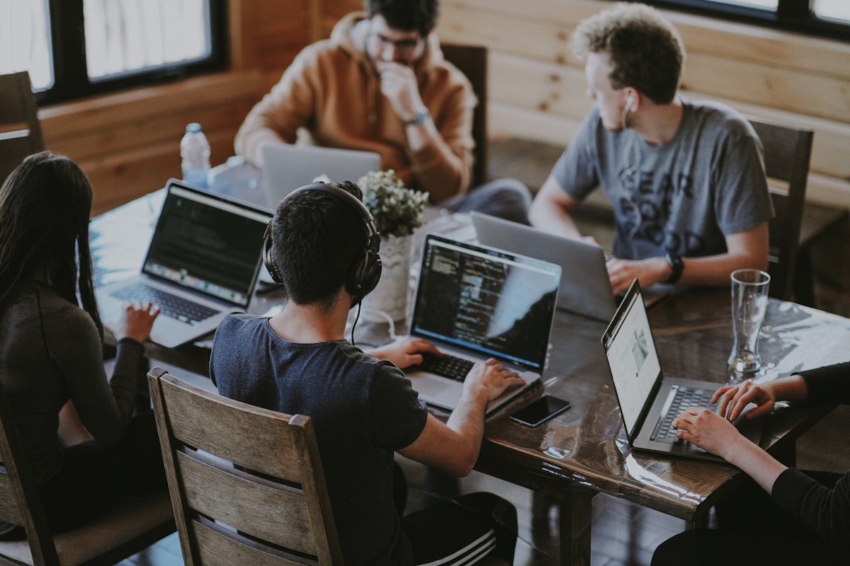 Collègues qui collaborent autour d'ordinateurs portables pendant une réunion d'équipe